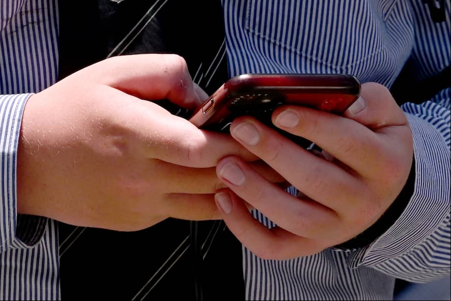 (FILES) A student uses his phone in Melbourne on November 27, 2024, as Australia looks to ban children under 16 from social media with claims social media platforms have been tarnished by cyberbullying, the spread of illegal content, and election-meddling claims. New Zealand's prime minister on May 6, 2025 proposed banning children under 16 from social media, stressing the need to protect them from the perils of big tech platforms. The proposed ban was modelled on that of Australia, which sits at the forefront of global efforts to regulate social media. (Photo by William WEST / AFP)