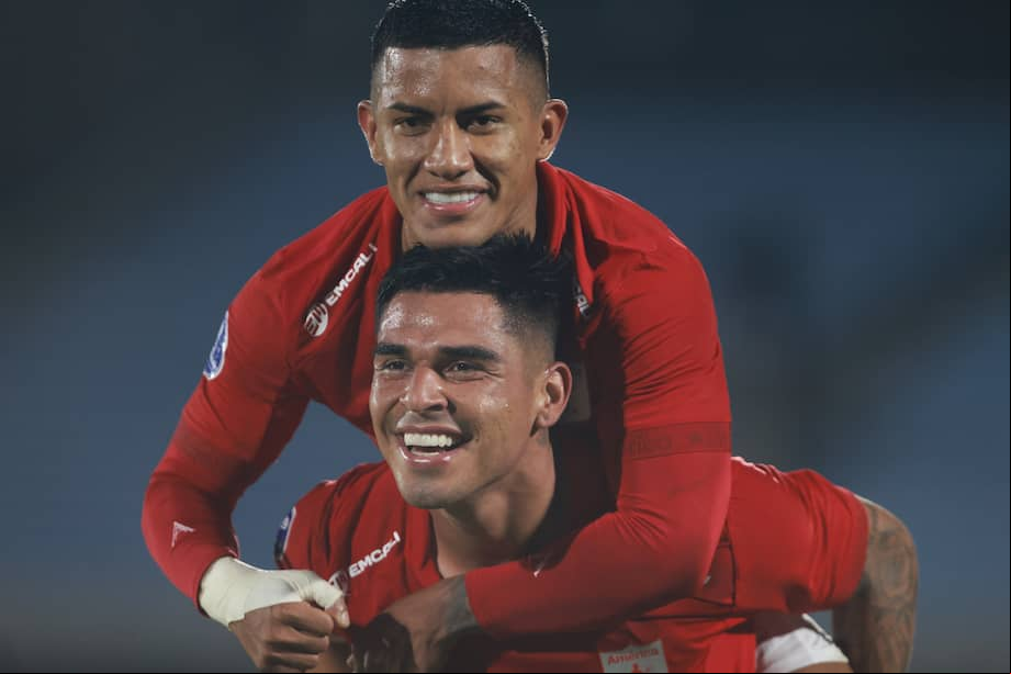 El peruano Luis Ramos (abajo) celebra con su compañero Cristian Barrios el tercer gol del América de Cali ante el Racing de Montevideo (Uruguay). EFE/ Gastón Britos
