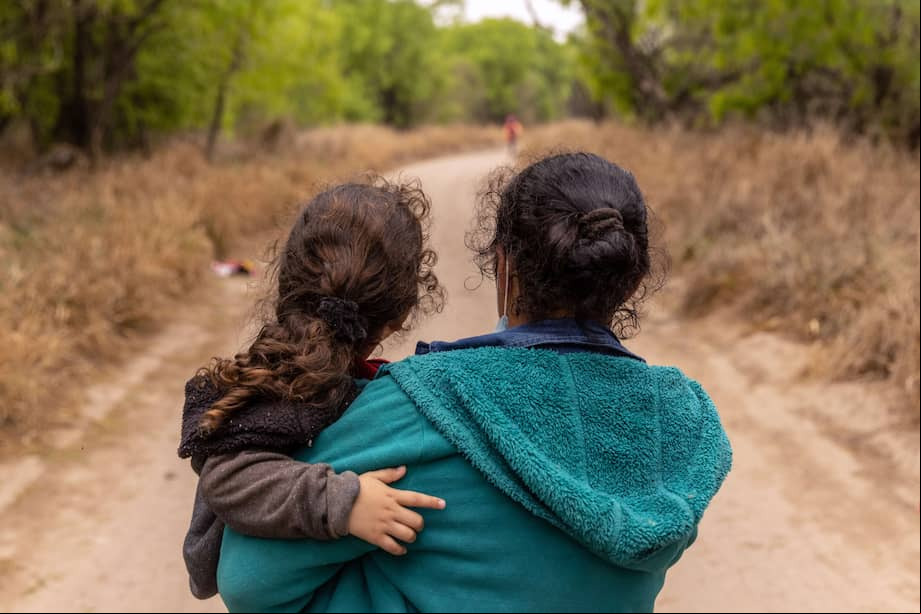 Una madre y su hija, migrantes hondureñas caminan hacia un puesto de control de la Patrulla Fronteriza de los Estados Unidos después de cruzar el Río Bravo.