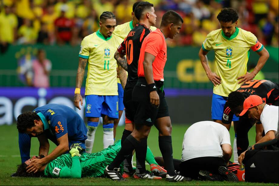 Alisson Becker (i) de Brasil y Davinson Sánchez de Colombia son atendidos tras un golpe de cabezas.